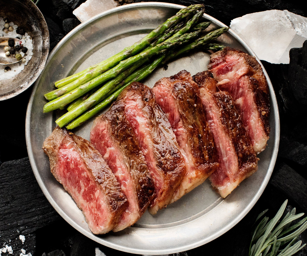 Wagyu New York Strip on a plate with asparagus