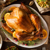 A cooked Market House turkey in a serving dish with oranges and cranberries.